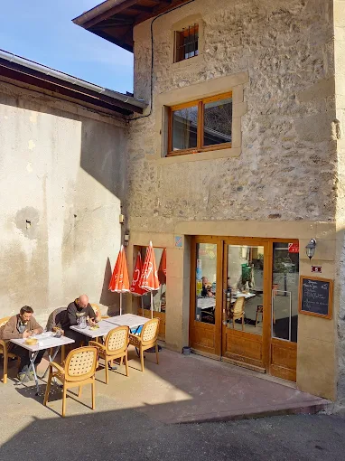 Terrasse ensoleillée de La Passerelle avec clients attablés sous les parasols